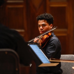 十大赌博正规老平台 student plays the violin during a concert.